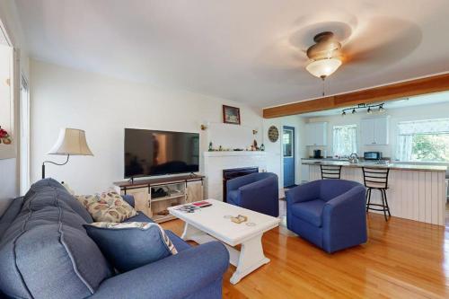 a living room with a couch and a table at Charming Cottage with Cozy Comfort and Easy Access to Outdoor Adventures in North Lamoine