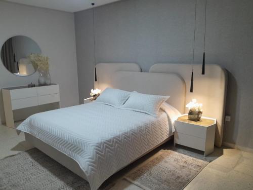 a bedroom with a white bed and a mirror at chez-moi sfax in Sfax