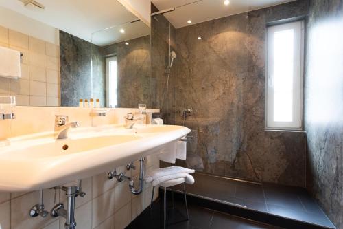a bathroom with two sinks and a shower at Romantik Hotel zur Sonne in Badenweiler