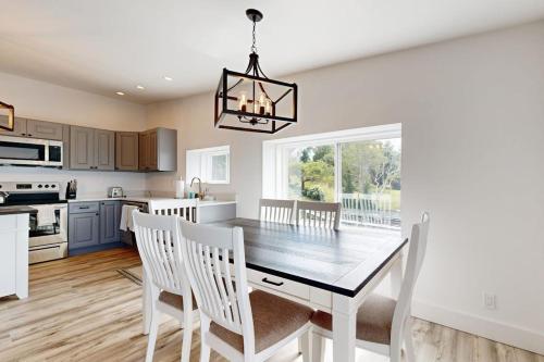 a kitchen and dining room with a table and chairs at Elegant Oceanfront Condo with Stunning Harbor Views & Spectacular Sunsets in Boothbay Harbor