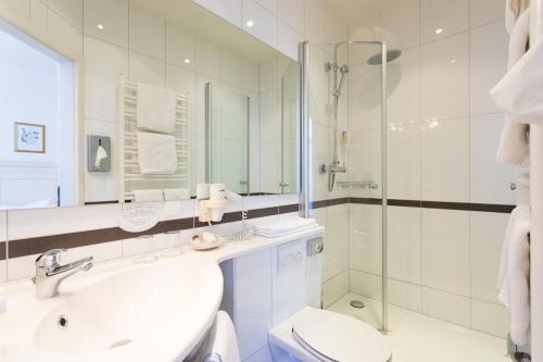 a bathroom with a sink and a toilet and a shower at Romantik Hotel zur Sonne in Badenweiler