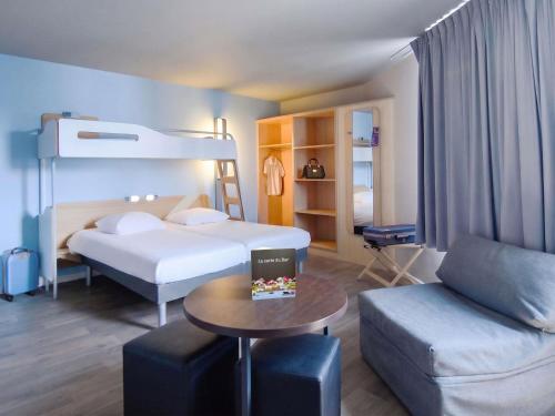 a hotel room with a bed and a couch at ibis budget Brest Centre Port in Brest