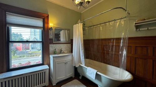 a bathroom with a tub and a sink and a window at Commanders Cabin, quaint apt steps to downtown in Camden