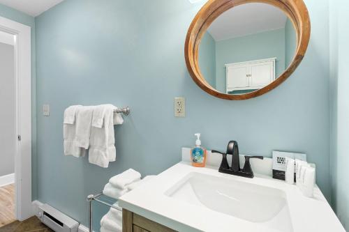 a bathroom with a white sink and a mirror at Mabel's Maine Studio on the River in Edgecomb