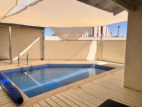 a swimming pool with an umbrella on top of a building at וילה אושר in Mitzpe Ramon