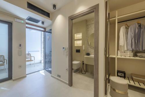 a bathroom with a door leading to a toilet and a sink at Zefyria Luxury Suites in Zefiría