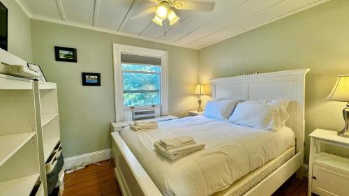 a bedroom with a white bed with towels on it at Commanders Cabin, quaint apt steps to downtown in Camden