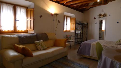 a living room with a couch and a bed at Coqueto estudio con terraza in La Zubia