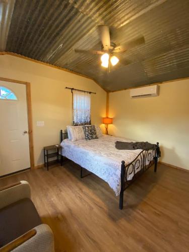 a bedroom with a bed and a ceiling fan at Hill Country Cabin 2 in Canyon Lake