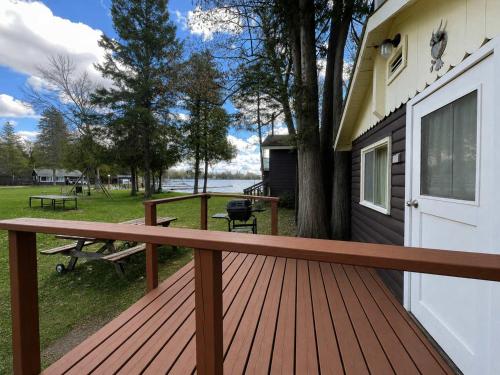 a wooden deck next to a house with a picnic table at Ambleside - 1-Bedroom Cottage #3 in Kawartha Lakes