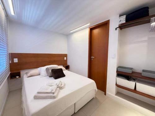 a bedroom with a white bed with towels on it at Triplex Luxo 2 Qtos c Churrasqueira na Rua das Pedras in Búzios