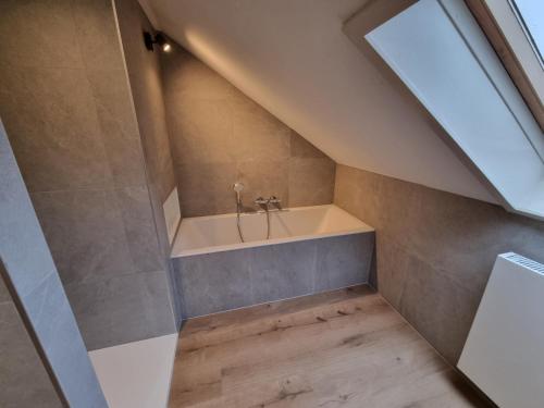 a bathroom with a bath tub in a attic at Val du Roannay in Stavelot