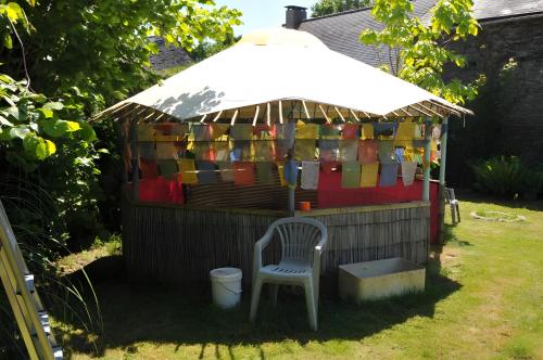 a gazebo with a chair and an umbrella at Chambre d'hôtes Erziwezh in Sainte-Marie