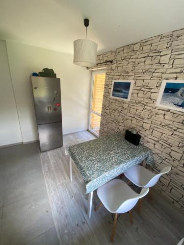 a kitchen with a table and a refrigerator at House Hostelli in Grzybowo