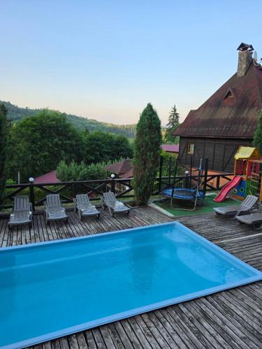 a pool on a deck with chairs and a playground at 12 Місяців-Травень in Slavske