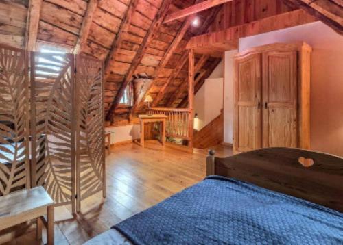 a bedroom with a bed and a wooden ceiling at La Maison d'Aimée in Vielle-Aure