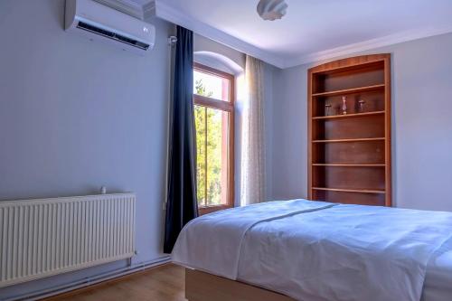 a bedroom with a bed and a window at Golden Tree in Karaağaç