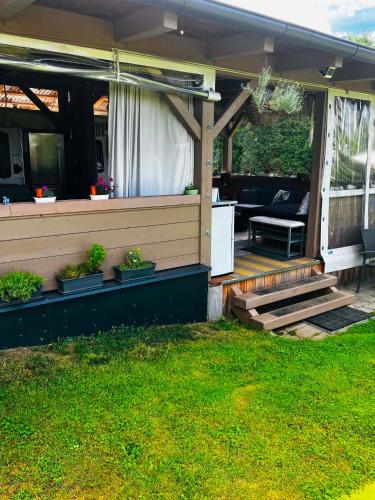 a house with a porch with a couch and a patio at Glamping Karavan u Konopiště in Chrášťany