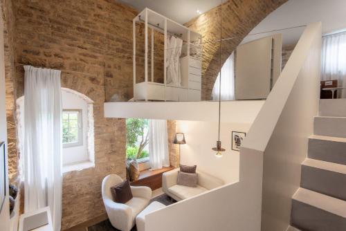 a staircase in a living room with a brick wall at Nun Assisi Relais & Spa Museum in Assisi