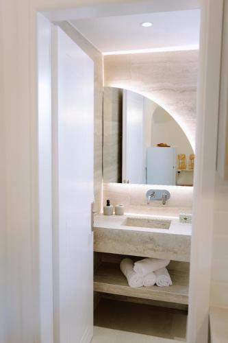 a bathroom with a sink and a mirror at Enki's Heaven Premium Apartments in Glinádhon