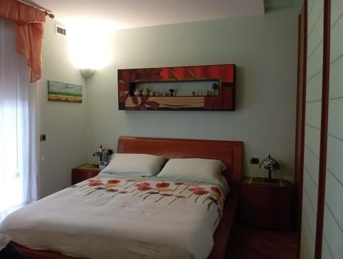 a bedroom with a bed and a painting on the wall at appartamento in Bisceglie