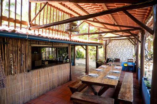 an outdoor dining area with a wooden table and benches at Pousada Templo Aláfia in Vera Cruz de Itaparica