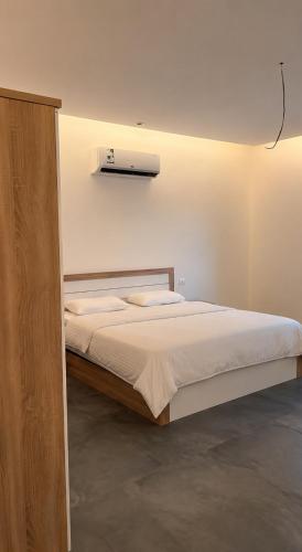 a bedroom with a large white bed with a light at فلل و شقق سحاب أبها in Abha