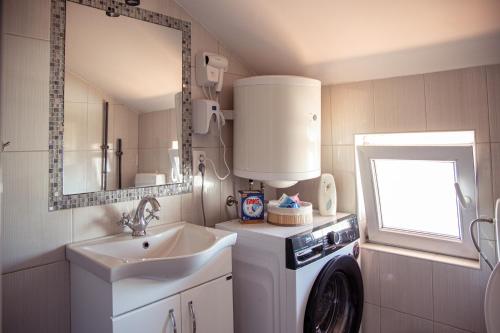 a bathroom with a sink and a washing machine at Apartments Kuc in Tivat