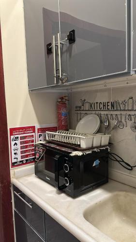 a toaster oven sitting on a counter next to a sink at غرفة وصالة دخول ذكي in Al Fayşalīyah