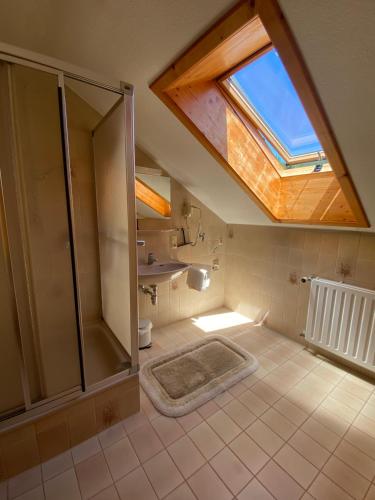 a bathroom with a shower and a skylight at Ferienwohnungen in Schönmünzach in Baiersbronn