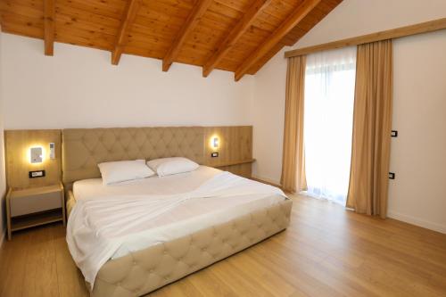 a bedroom with a large bed and a large window at Guesthouse Micaj LA KRIDEA in Himare