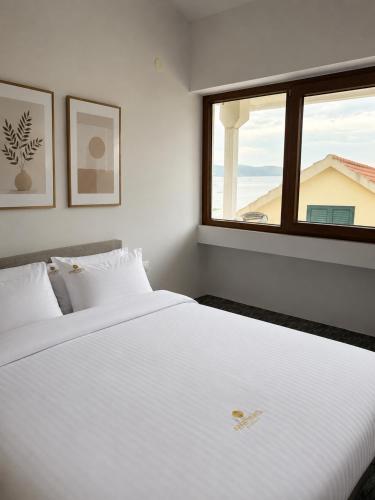 a bedroom with a large white bed with a window at 101 Apartments in Igalo