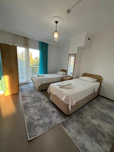 ein Hotelzimmer mit zwei Betten und einem großen Fenster in der Unterkunft Elfida Apart in Datca