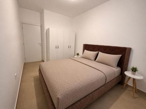 a bedroom with a large bed and a white wall at Comfort Residence in Tuzi