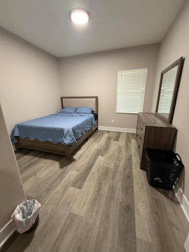 a bedroom with a bed and a wooden floor at Matthews Blue House in Wilmer