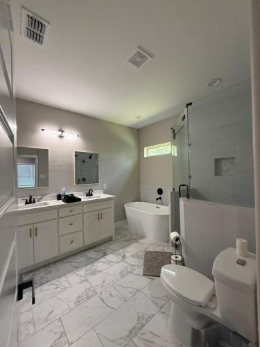 a bathroom with a tub and a toilet and a sink at Matthews Blue House in Wilmer