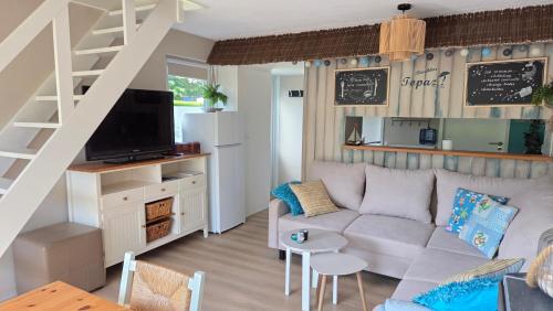 a living room with a couch and a staircase at Vakantiehuis Topaz in Bruinisse