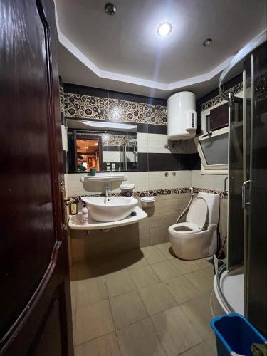 a bathroom with a toilet and a sink at Kendaw home in Hihyā