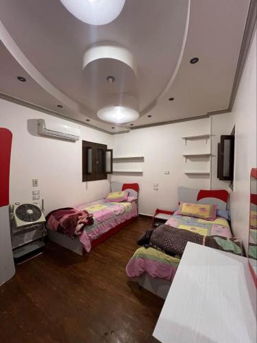 a room with two beds and a table in it at Kendaw home in Hihyā