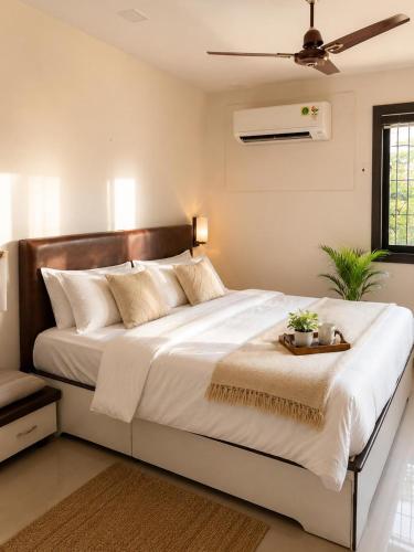 a bedroom with a large white bed with a tray on it at Jacuzzi Room in a shared Villa with Swimming pool in Thane