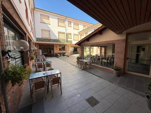 an outdoor patio with tables and chairs and a building at Hotel Chiffre in Albi