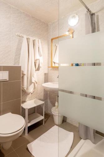 a white bathroom with a toilet and a sink at K&D Home in Rab