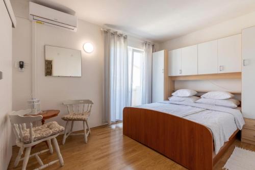 a bedroom with a bed and a table and chairs at K&D Home in Rab