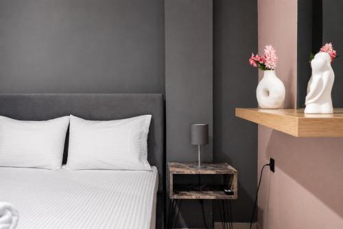 a bedroom with a bed and a vase with flowers on a shelf at Swan Paradise Tolo in Tolo