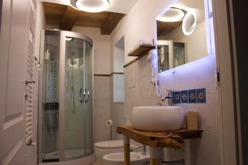 a bathroom with a sink and a shower and a toilet at Pupa1824 casedamare in Lentiscosa