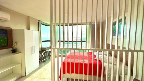 a crib in a bedroom with a view of the ocean at Studios Praia Grande - VISTA MAR in Arraial do Cabo