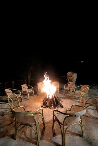 a group of chairs around a fire at night at Hotel Plaza Park in Nathia Gali