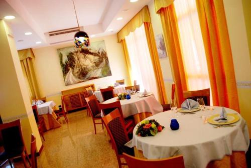 a restaurant with two tables and chairs in a room at Hotel San Giacomo in Monteprandone