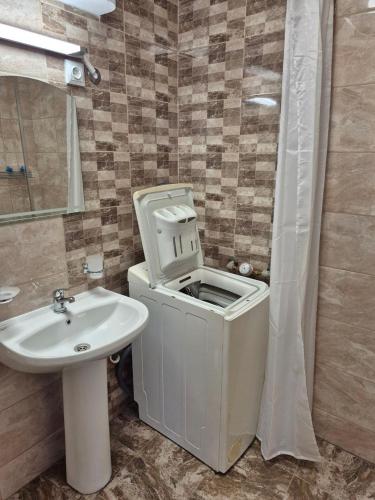 a bathroom with a toilet and a sink at Къща за гости Баврия in Ravda