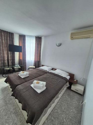 a hotel room with two beds with towels on them at Къща за гости Баврия in Ravda